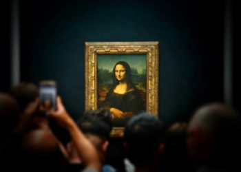 A group of people taking pictures of a painting