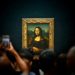 A group of people taking pictures of a painting