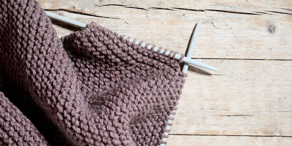 A pair of knitted gloves hanging on a clothesline