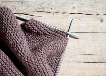 A pair of knitted gloves hanging on a clothesline