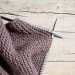 A pair of knitted gloves hanging on a clothesline
