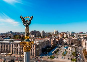 a view of a city with a statue in the middle