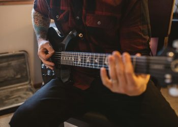 a man playing a guitar in a room