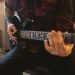 a man playing a guitar in a room