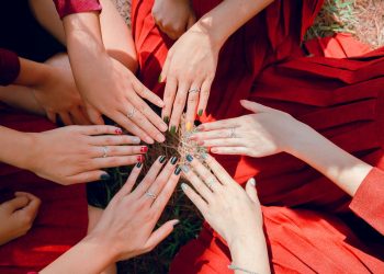 A vibrant top view of women showcasing painted nails and rings, emphasizing friendship and togetherness.