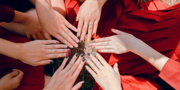 A vibrant top view of women showcasing painted nails and rings, emphasizing friendship and togetherness.